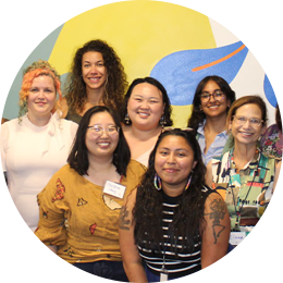 A group women of various ethnicities posing for the camera, smiling